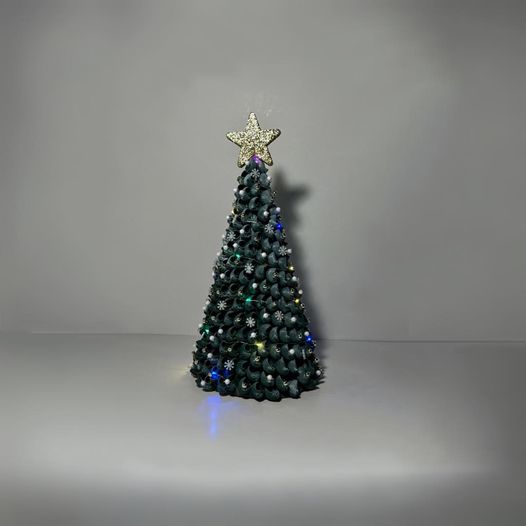 Green Christmas tree with white ornaments gold star and colorful light