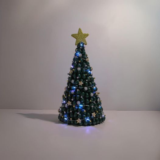 Christmas tree made of spaghetti painted green with gold ornaments and gold star.