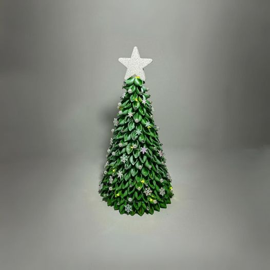 Green Christmas tree with yellow lights, white star and pink ornaments.