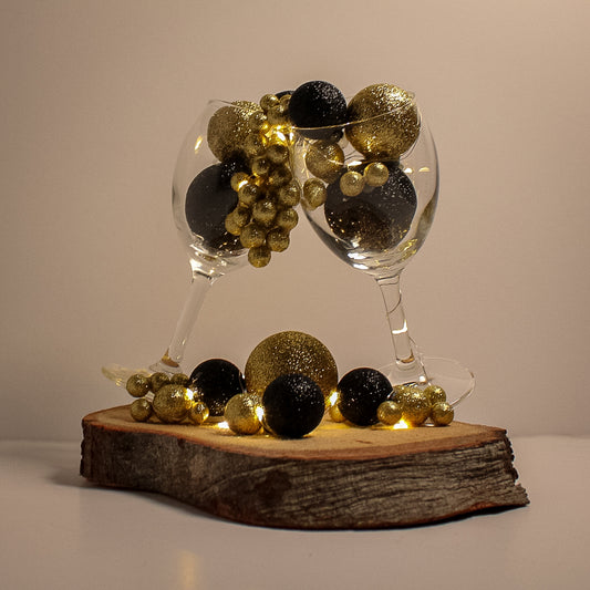 Beautiful Christmas decoration made of natural tree trunk, wine glass and ornaments