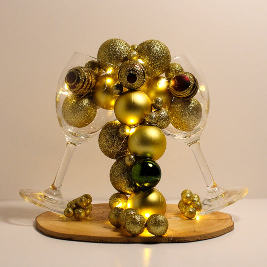 Beautiful Christmas decoration made of natural tree trunk, wine glass and ornaments