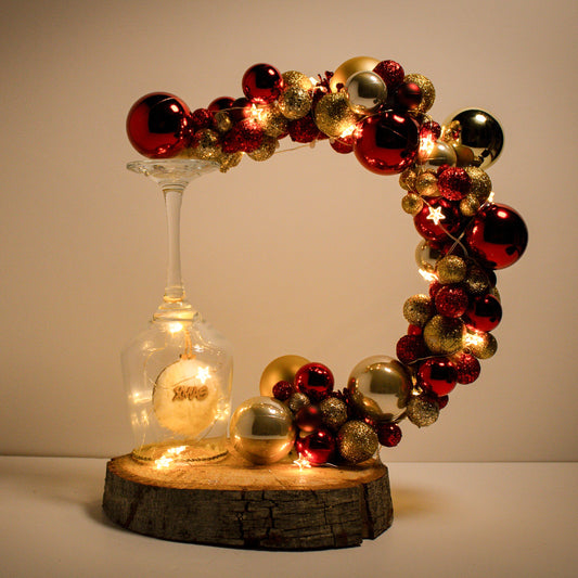 Beautiful Christmas decoration made of natural tree trunk, wine glass and ornaments