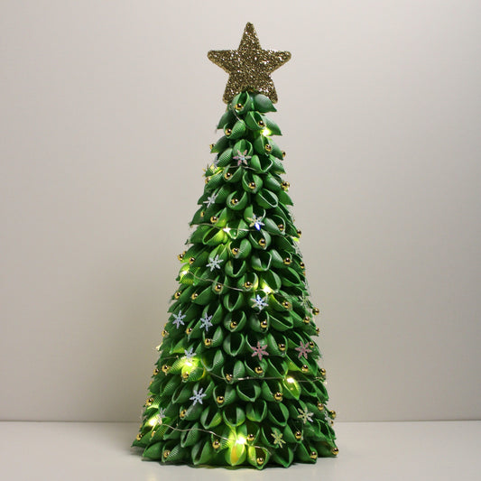 Green Christmas tree with yellow lights, gold star and ornaments.